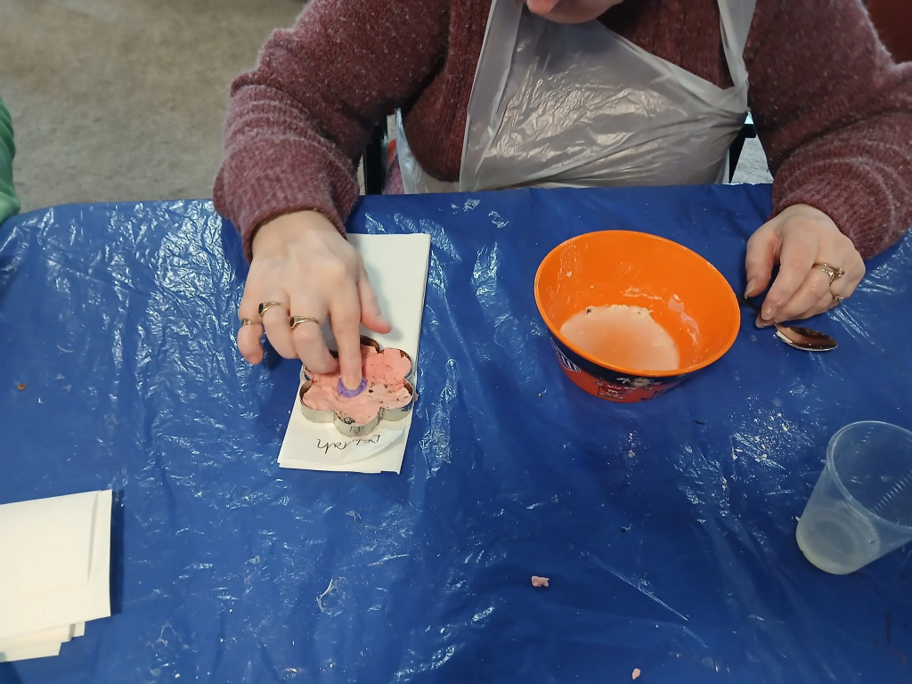 Picture of a customer making a flower-shaped seed bomb