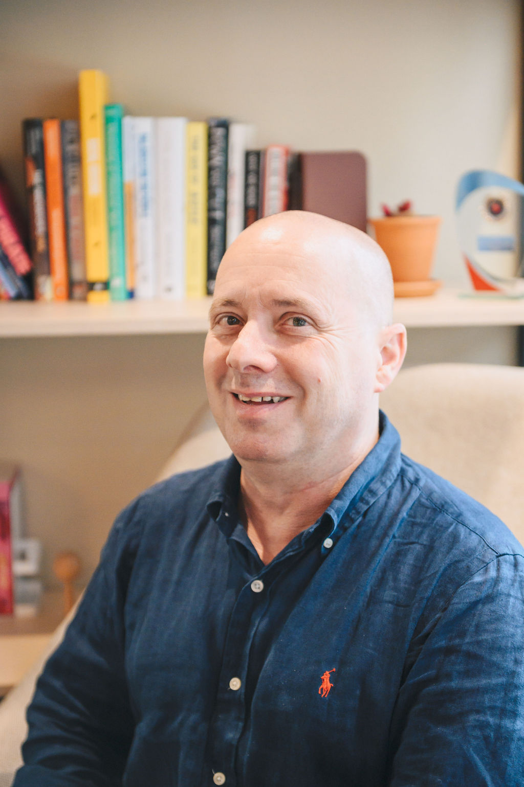 A photo of Larry Gold. He is wearing a blue shirt and smiling at the camera.